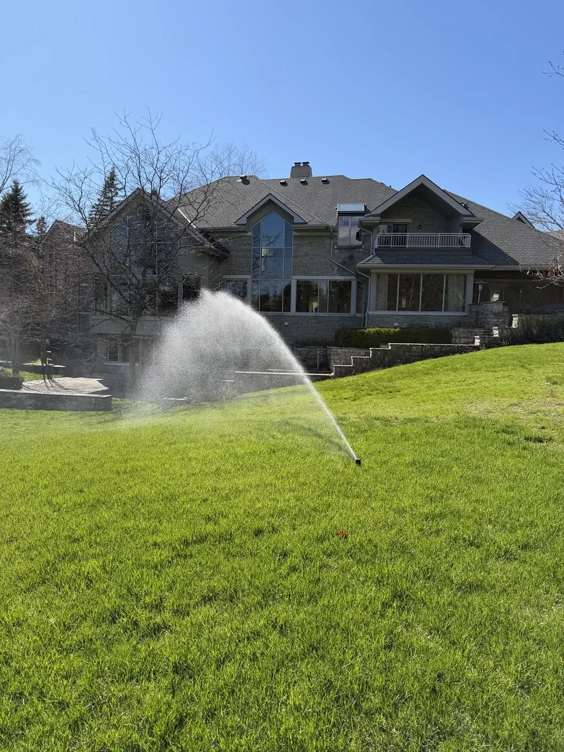 Sprinkler system running on a finished lawn